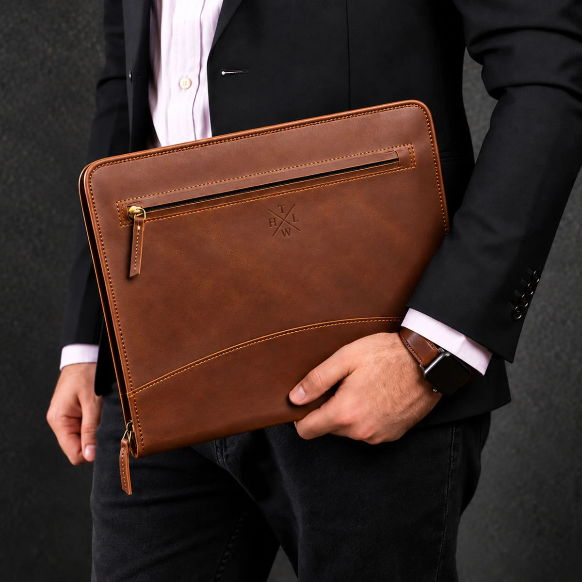 Brown leather portfolio folder held by a professional in a black suit