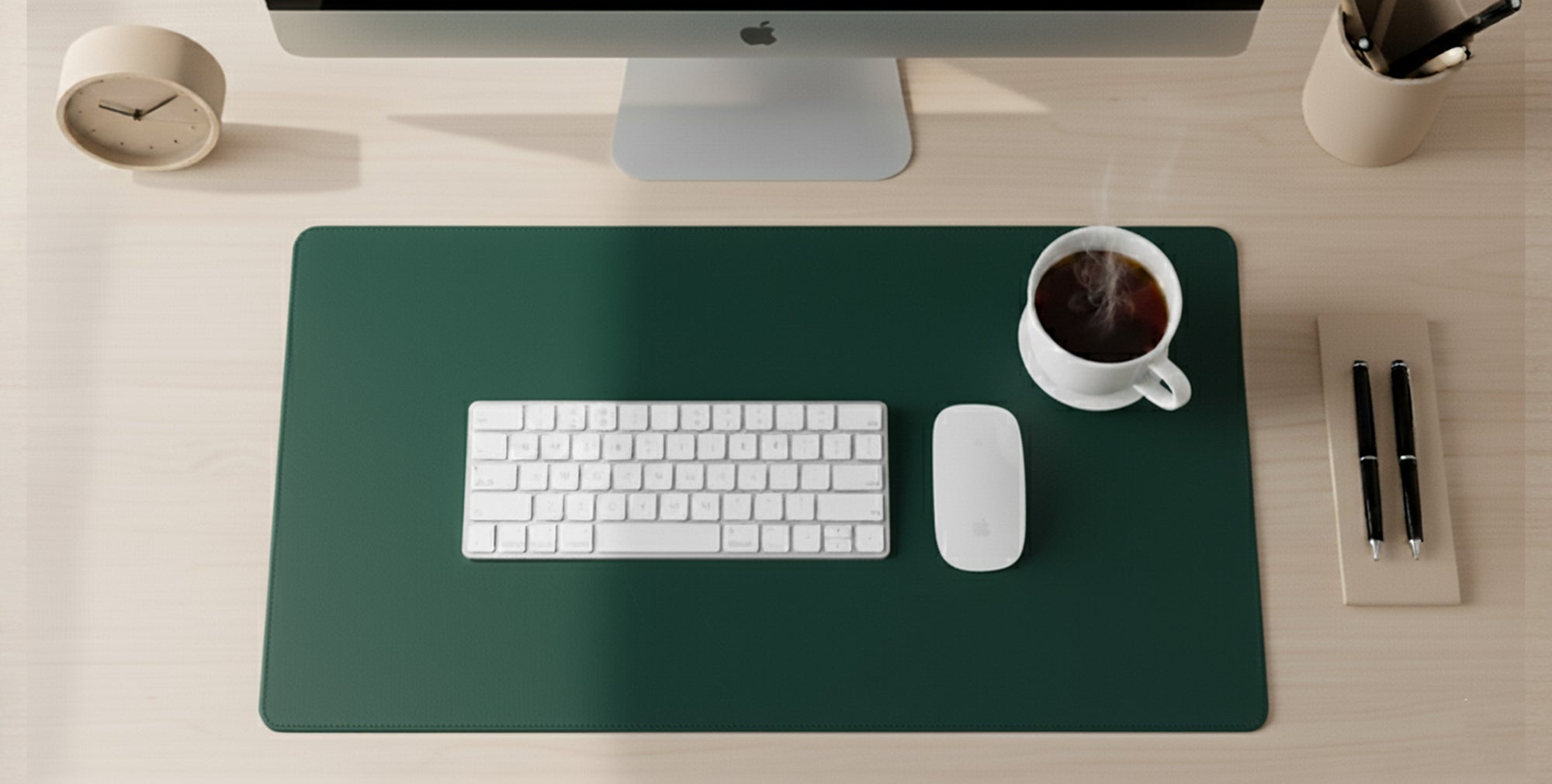 Desk setup with a computer monitor, keyboard, mouse, and coffee cup on a green mouse pad.