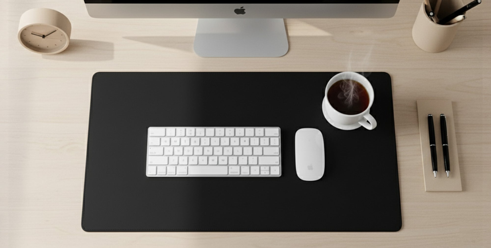 A tidy office desk with a computer keyboard, mouse, and a cup of coffee, set against a light wood background.