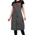 Person wearing a gray apron with brown leather straps on a white background