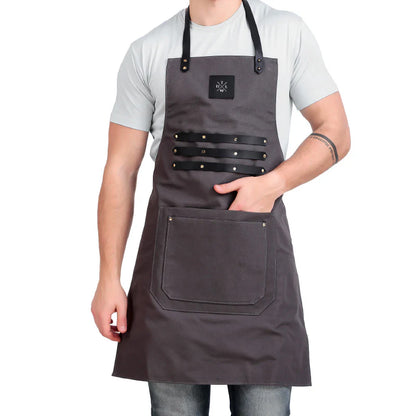 Person wearing a gray apron with black straps on a white background
