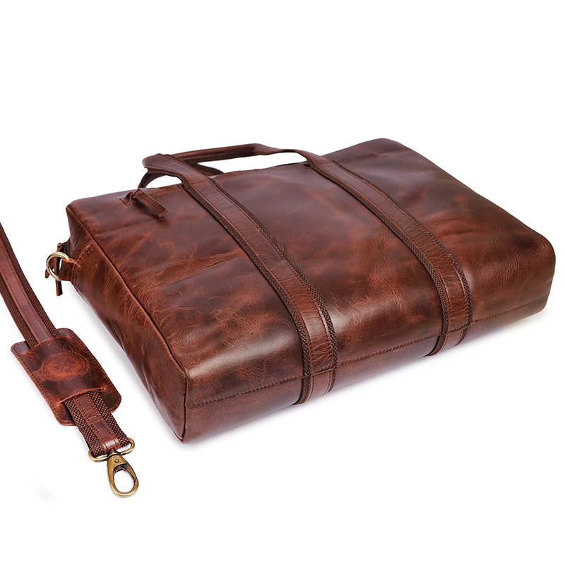 Brown leather duffel bag with strap on a white background