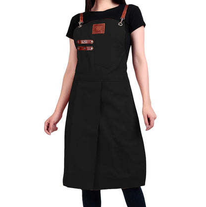 Black apron with brown leather straps worn by a person on a white background