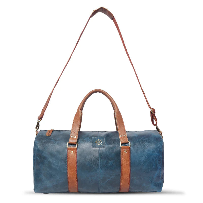 Blue duffel bag with brown leather straps on a white background
