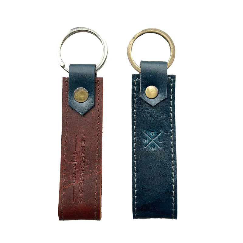 Two leather keychains, one brown and one black, on a white background.