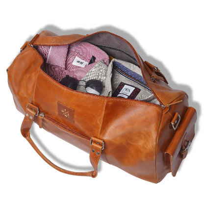Brown leather duffel bag with clothes inside on a white background