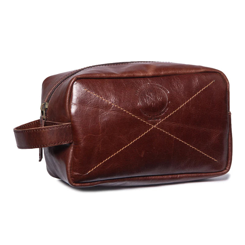 Brown leather toiletry bag with stitching detail on a white background