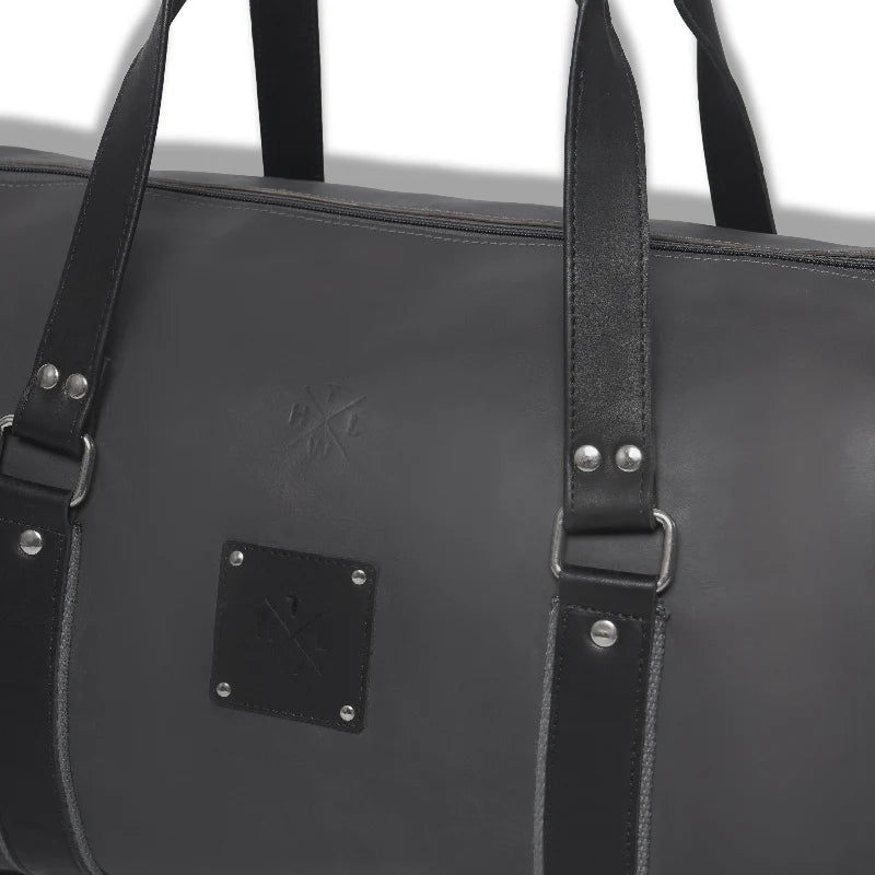 Black leather bag with straps and a visible brand logo on a white background