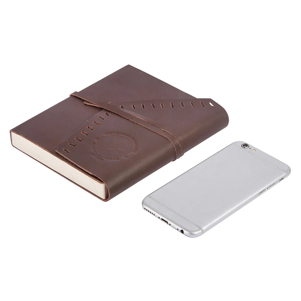 Brown leather notebook and silver phone on a white background