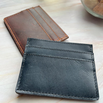 Black leather wallet on a light wooden surface