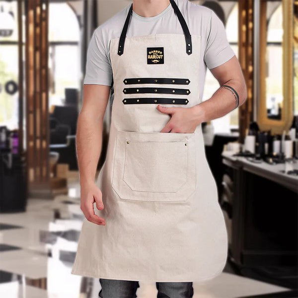 Person wearing a beige apron with a logo in a barbershop setting