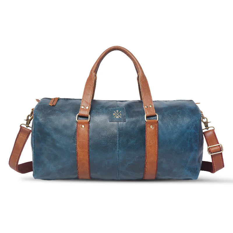 Blue duffel bag with brown leather straps on a white background