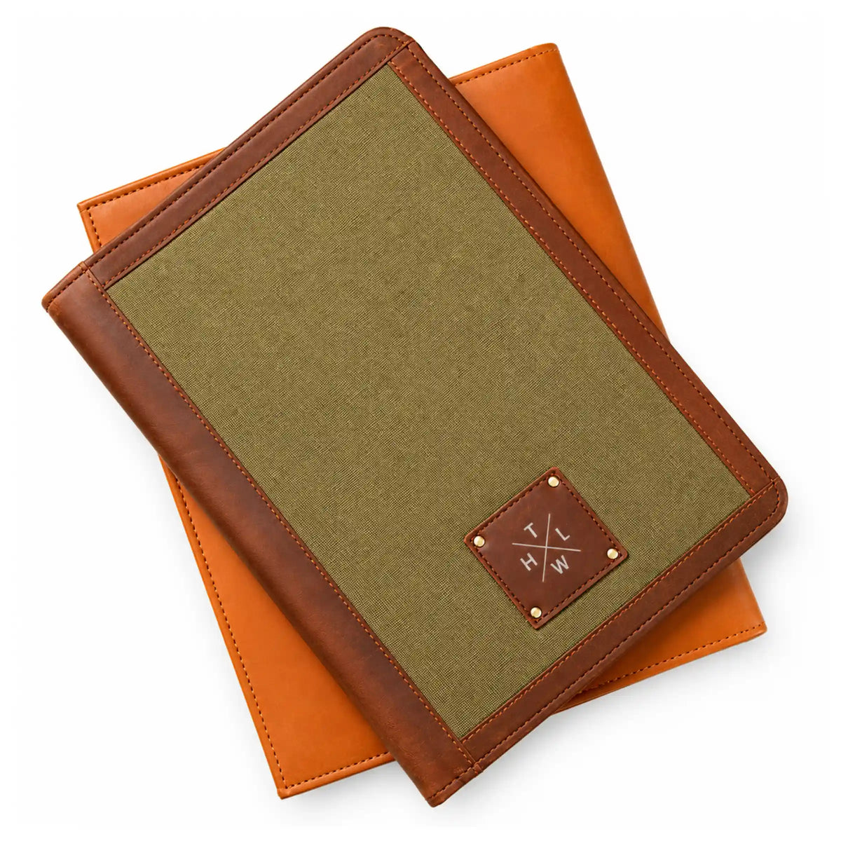 Olive green canvas folder with brown leather edging and a centered leather logo patch held in both hands