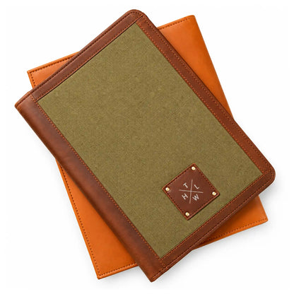 Olive green canvas folder with brown leather edging and a centered leather logo patch held in both hands