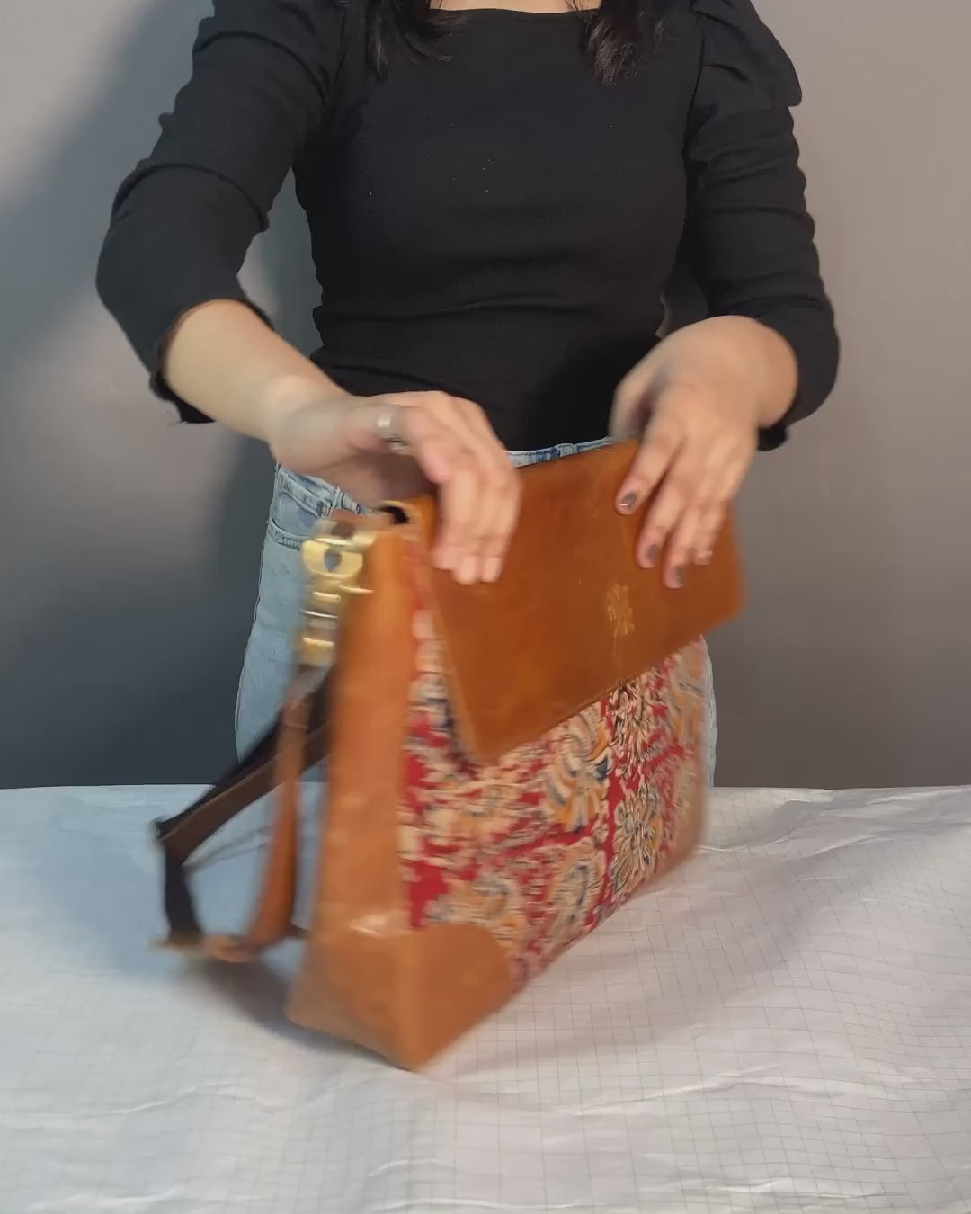 A woman holds a laptop bag containing a laptop, showcasing her readiness for work or travel.
