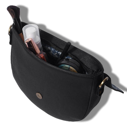 Black crossbody bag with cosmetic items on a white background