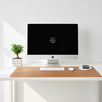 Modern desk setup with a computer monitor, keyboard, mouse, and phone on a wooden desk pad.