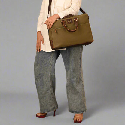 Person holding a green handbag against a gray background