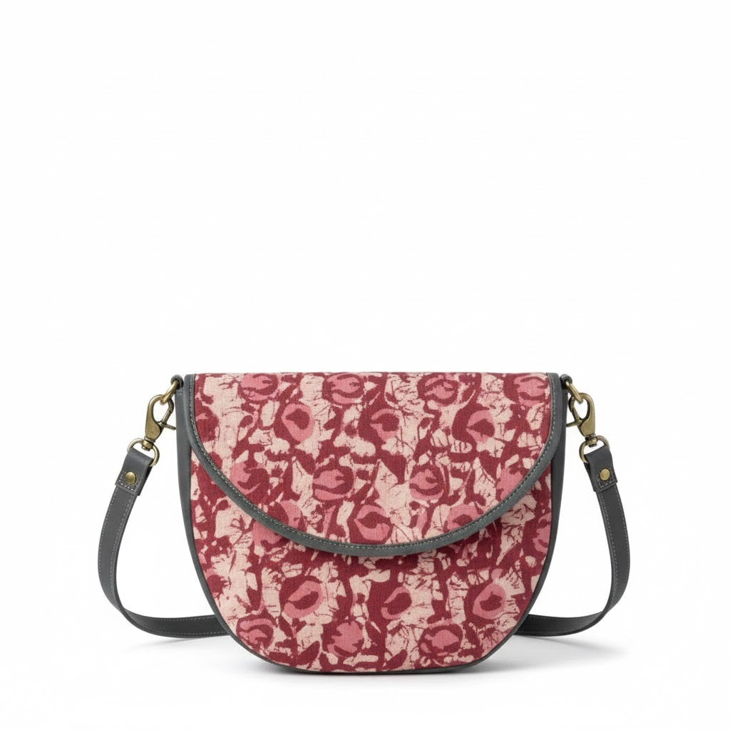 Floral patterned handbag with a strap on a white background